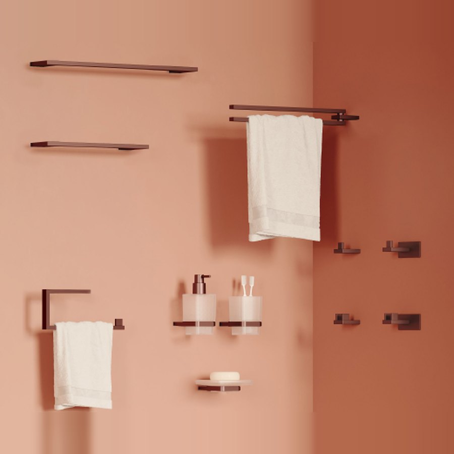 Accesorios de baño coordinados en acabado bronce sobre pared terracota